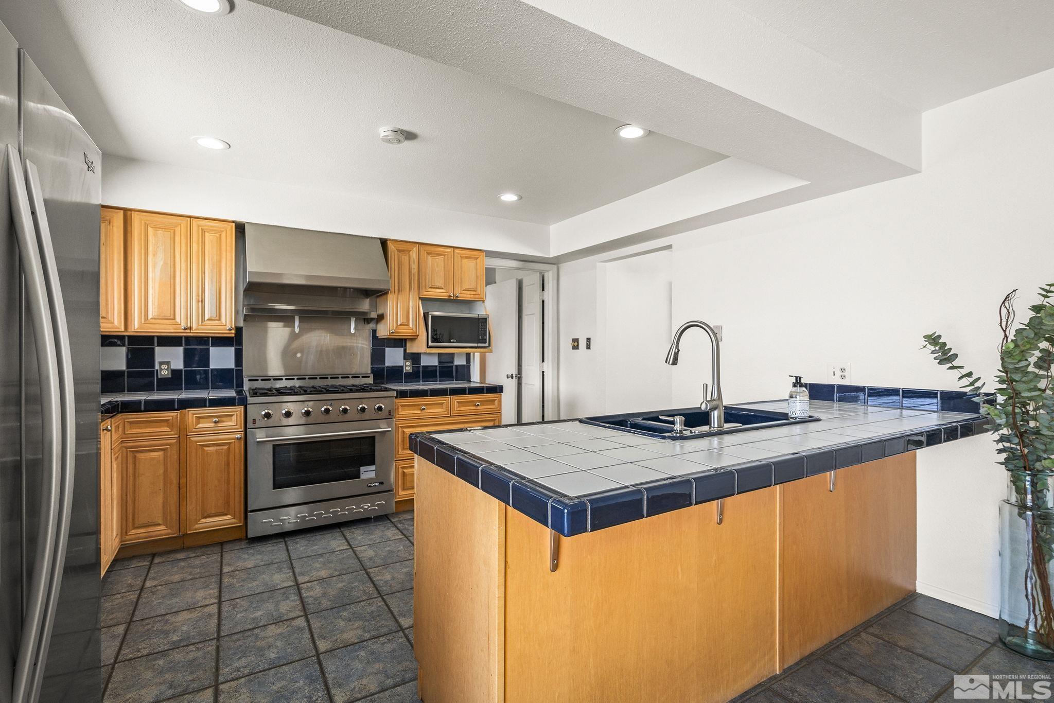 1680 Hunter Lake Drive Reno, NV 89509 - Photo 11 of 26 a kitchen with stainless steel appliances granite countertop a sink stove and refrigerator