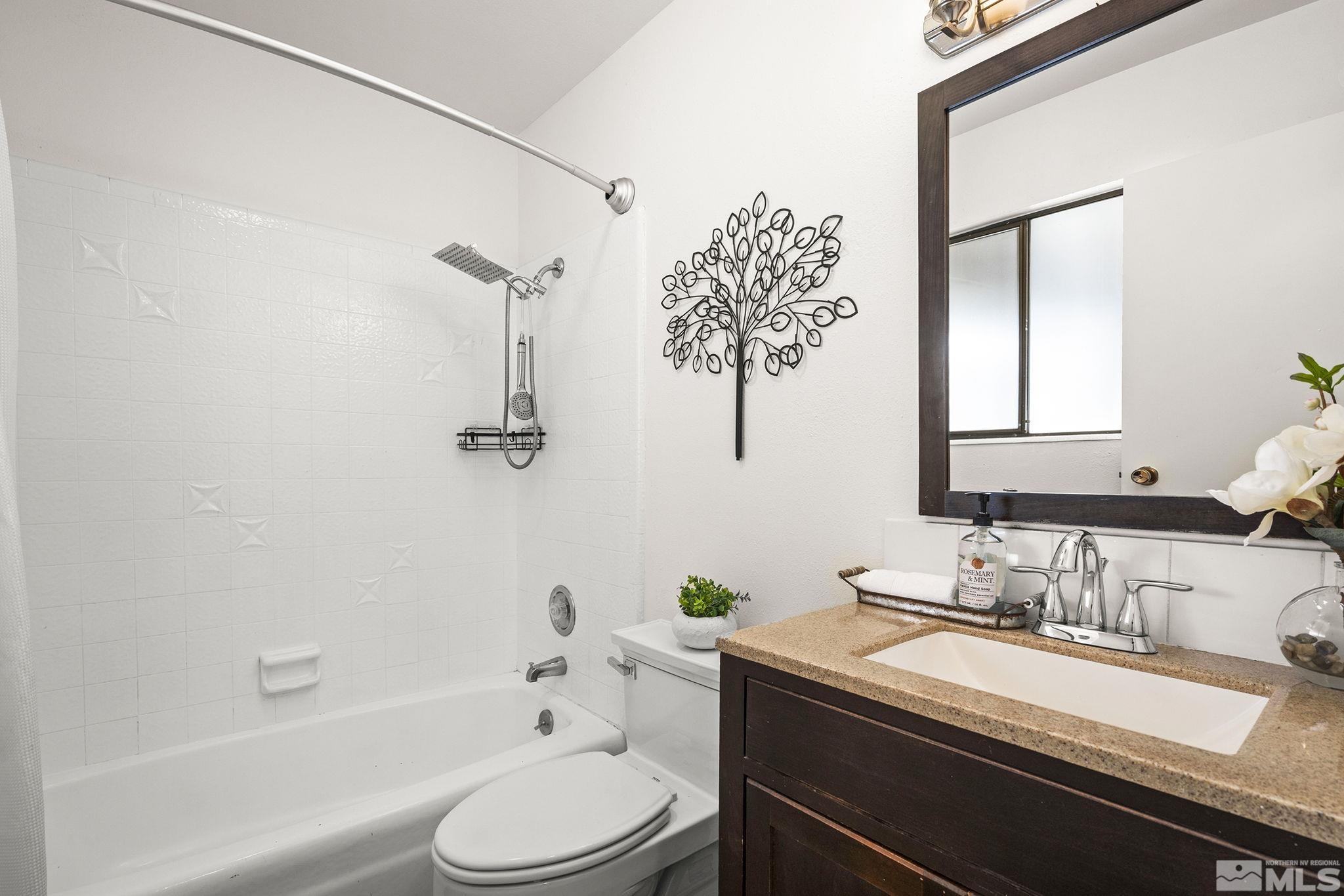 1680 Hunter Lake Drive Reno, NV 89509 - Photo 18 of 26 a bathroom with a granite countertop sink a toilet and shower