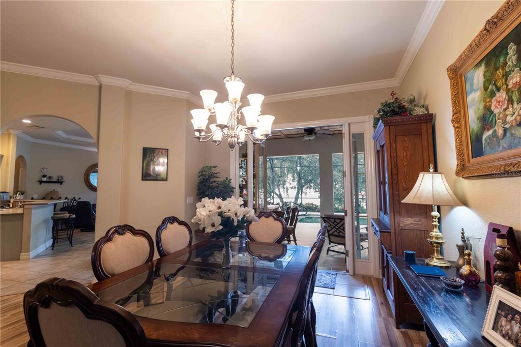 2329 South Lake Reedy Boulevard Frostproof, FL 33843 - Photo 14 of 86 a dining room with furniture a chandelier and wooden floor