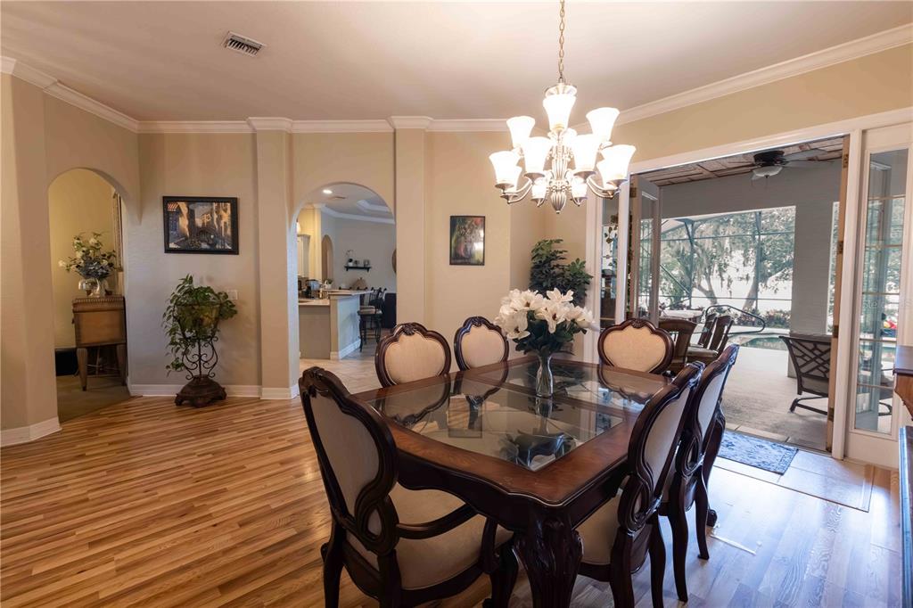 2329 South Lake Reedy Boulevard Frostproof, FL 33843 - Photo 15 of 86 a dining room with furniture a chandelier and wooden floor
