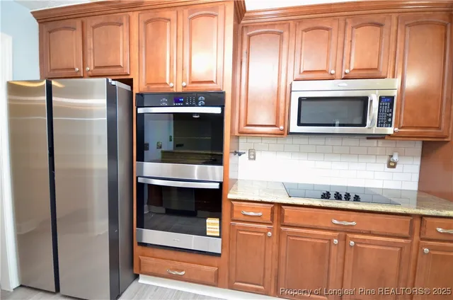 a kitchen with stainless steel appliances granite countertop a refrigerator and cabinets