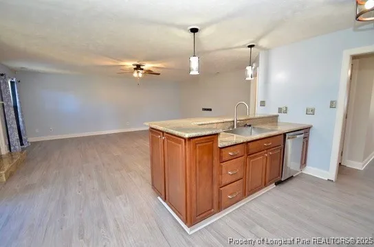 a kitchen with a sink a stove cabinets and wooden floor