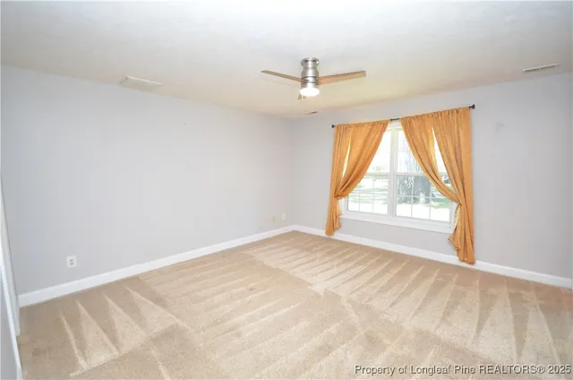 an empty room with a window and a ceiling fan