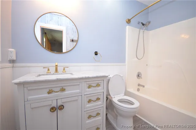 a bathroom with a toilet sink vanity and mirror