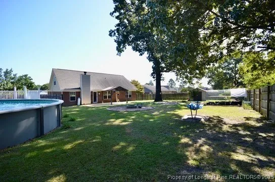a view of a yard with plants and large trees
