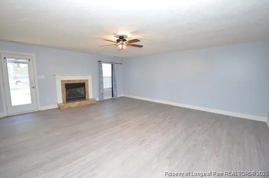 an empty room with windows and fireplace
