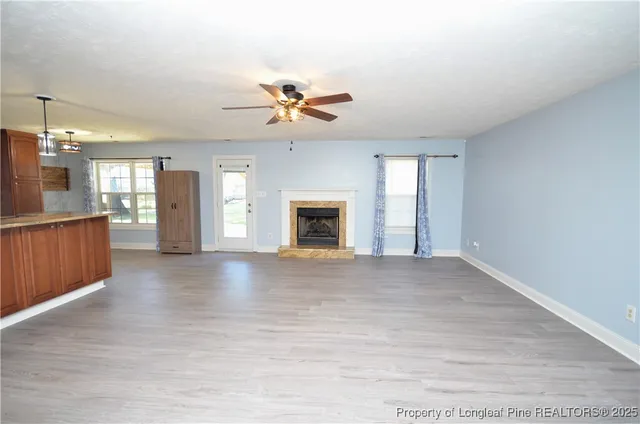 a view of an empty room with a fireplace and a window