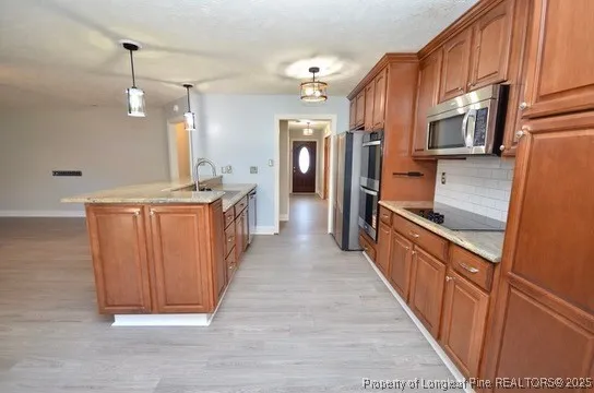 a kitchen with stainless steel appliances granite countertop a refrigerator and a sink