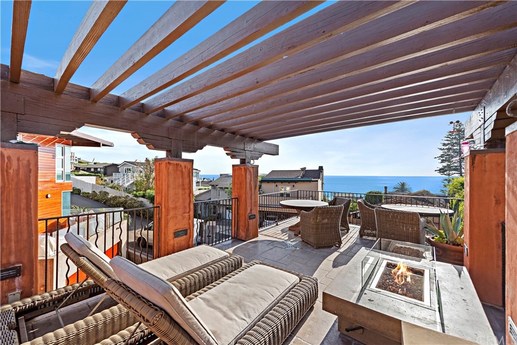 a view of a roof deck with couches chairs with wooden floor