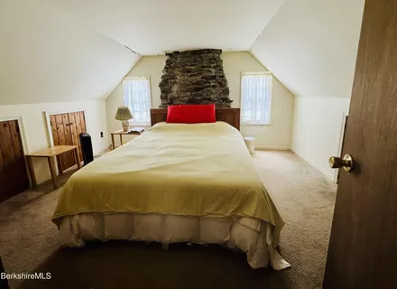 a bed sitting in a bedroom next to a window