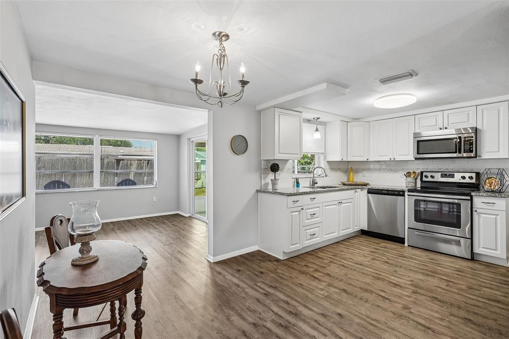 7215 Mayfield Drive Port Richey, FL 34668 - Photo 3 of 52 a kitchen with stainless steel appliances a refrigerator and a stove top oven