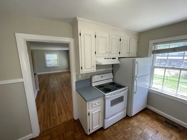 a kitchen with white cabinets and white appliances