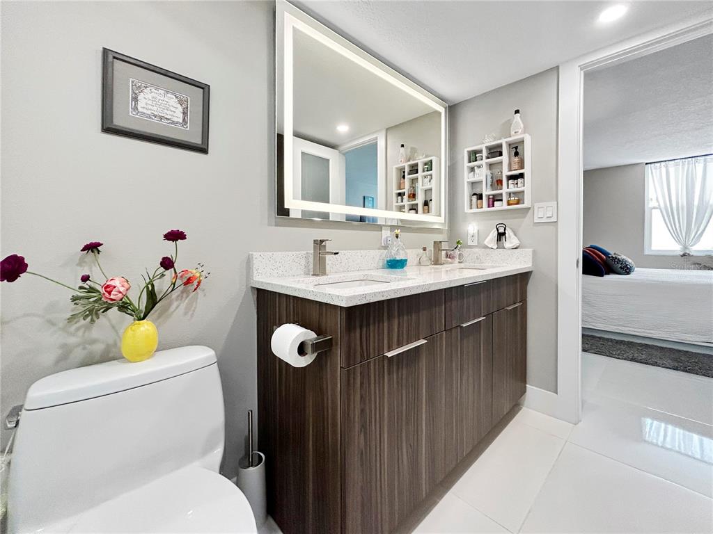 101 South Gulfstream Avenue, Unit 9C Sarasota, FL 34236 - Photo 21 of 24 a bathroom with a sink mirror vanity toilet and shower