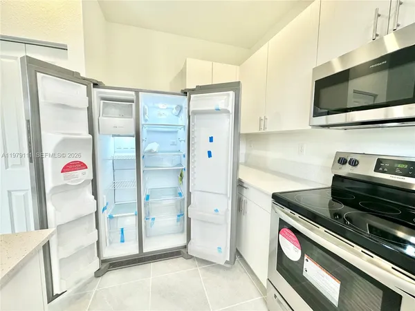 a kitchen with stainless steel appliances a refrigerator and a stove top oven