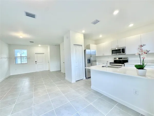 a view of kitchen with stainless steel appliances a refrigerator and a stove top oven