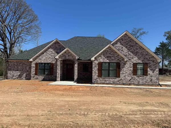 a front view of a house with a yard covered with snow