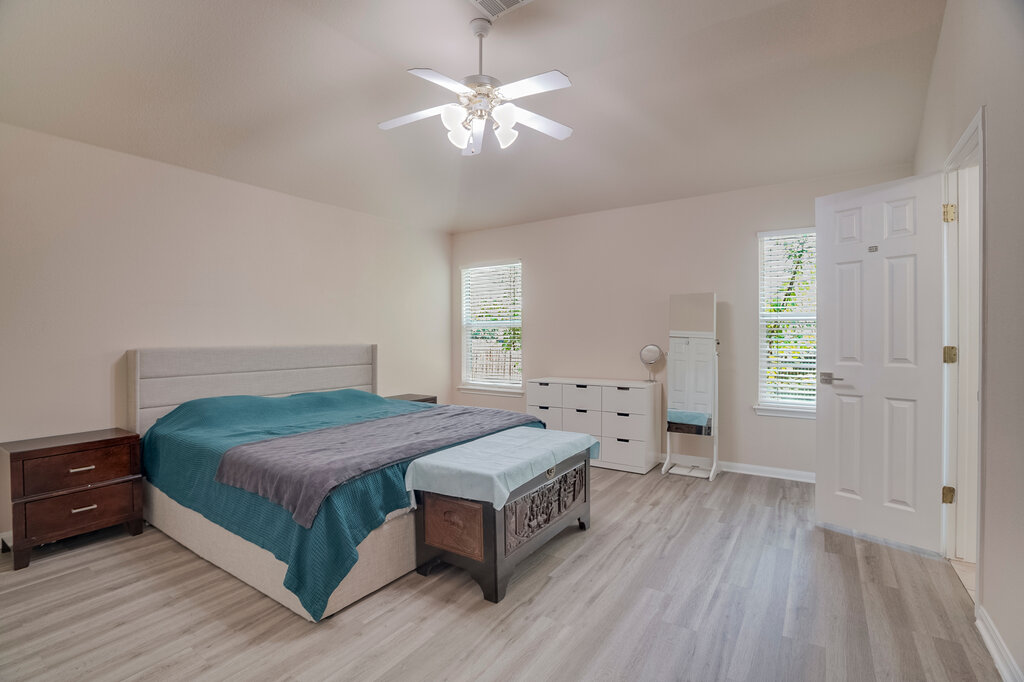 2724 Kickapoo Cavern Drive Pflugerville, TX 78660 - Photo 13 of 24 Natural light illuminates this bedroom, offering a peaceful retreat with light wood flooring and a refreshing ceiling fan.