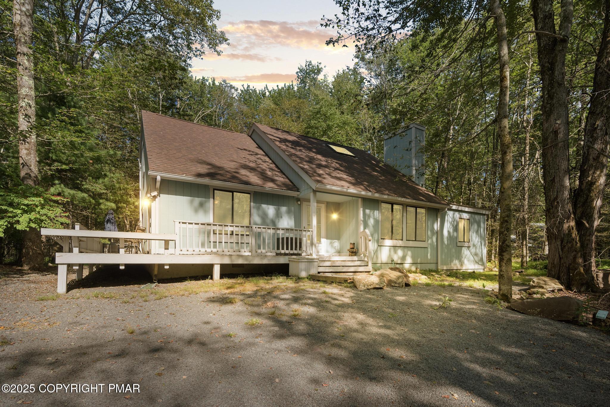 a view of a white house that has a tree on the side of it