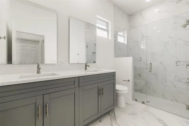 a bathroom with a double vanity sink toilet and shower