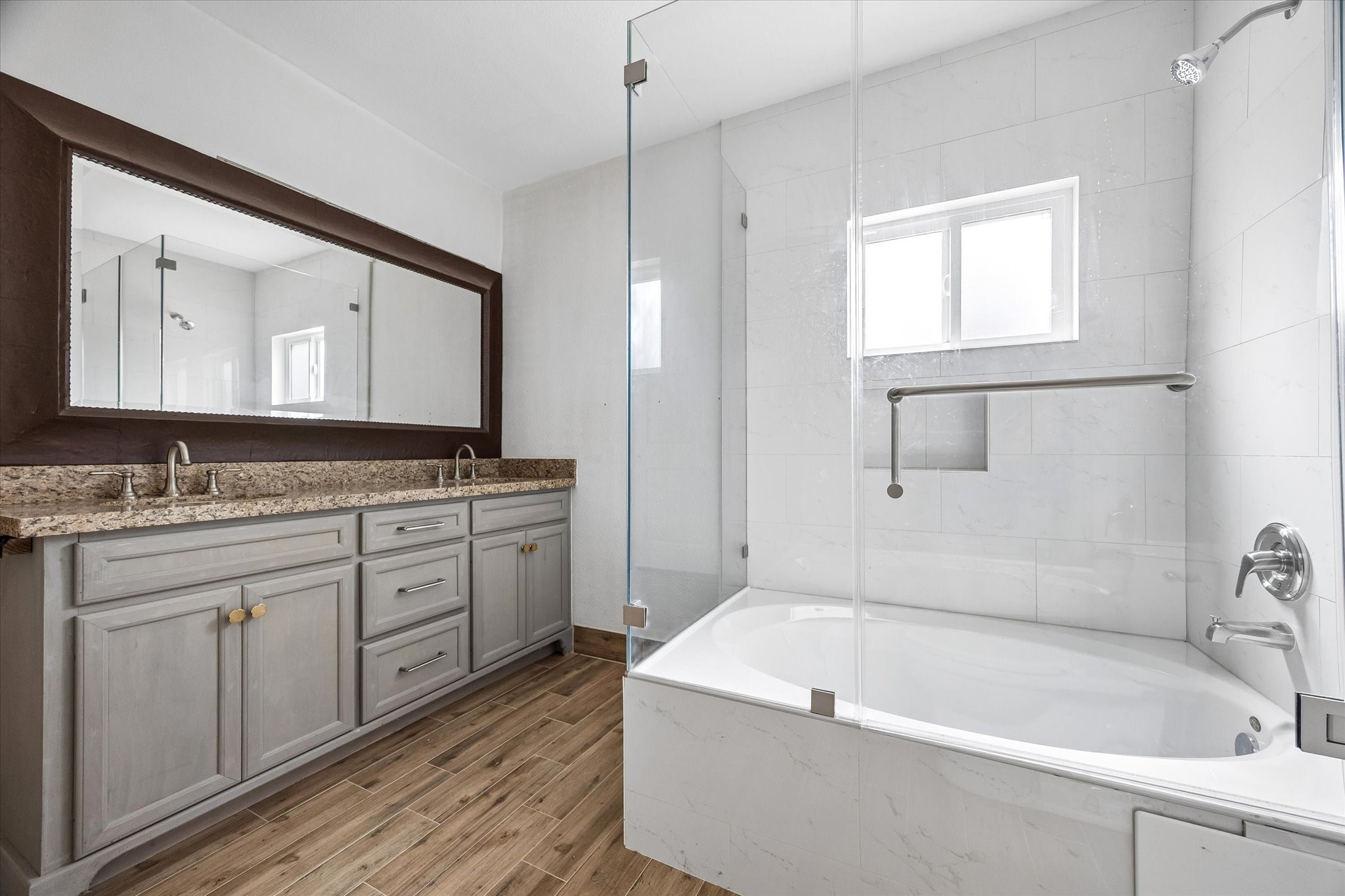 6529 Rolla Street Houston, TX 77055 - Photo 15 of 28 The primary suite features dual sinks, granite countertops and a glass encased soaking tub.