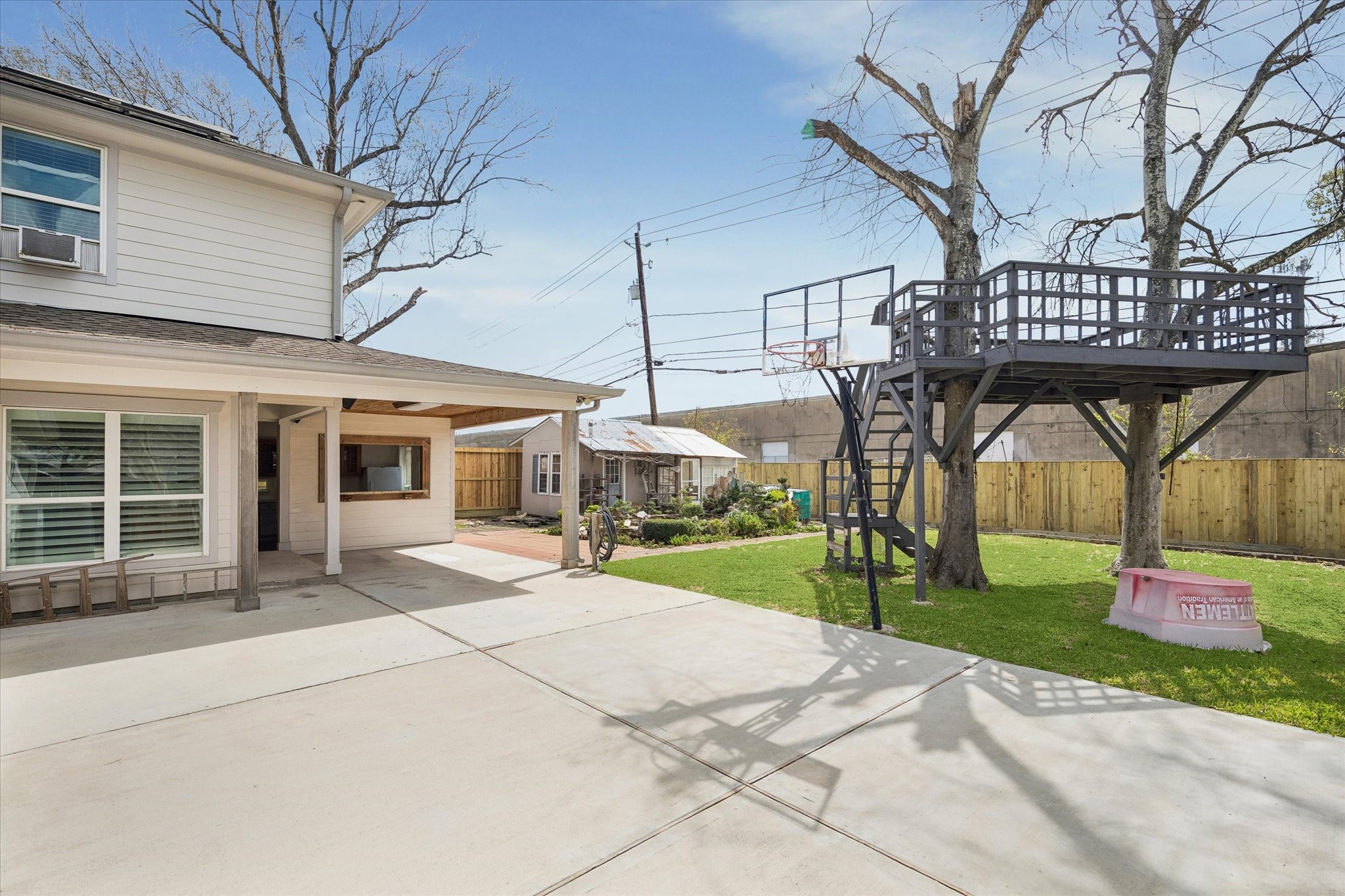 6529 Rolla Street Houston, TX 77055 - Photo 25 of 28 Outside, enjoy a peaceful backyard retreat with a covered porch overlooking a serene pond, a charming treehouse for the kids, and a privacy fence for added seclusion.