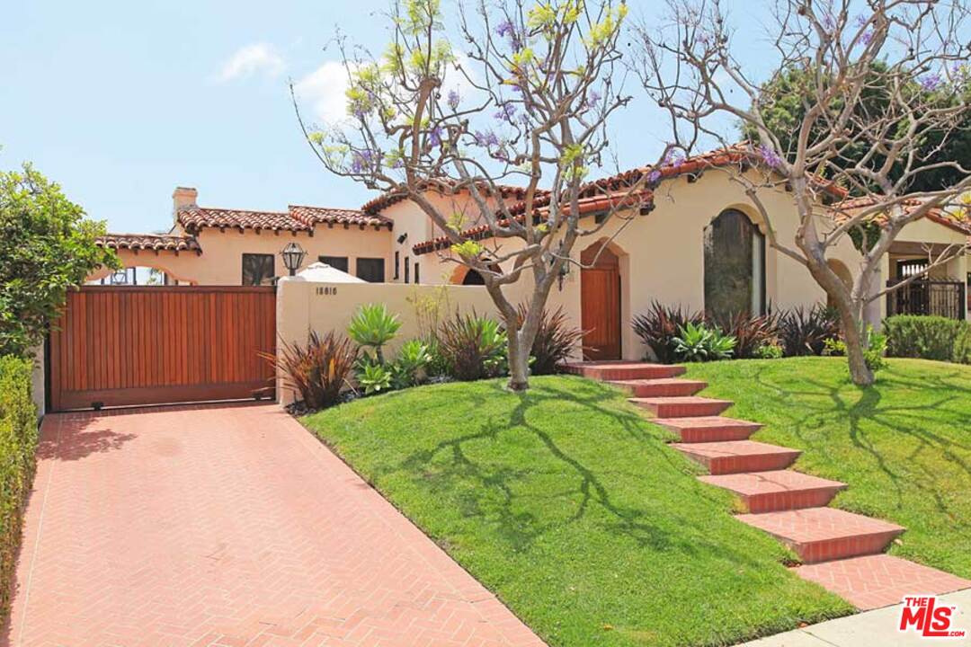 a front view of a house with a yard and flower plants