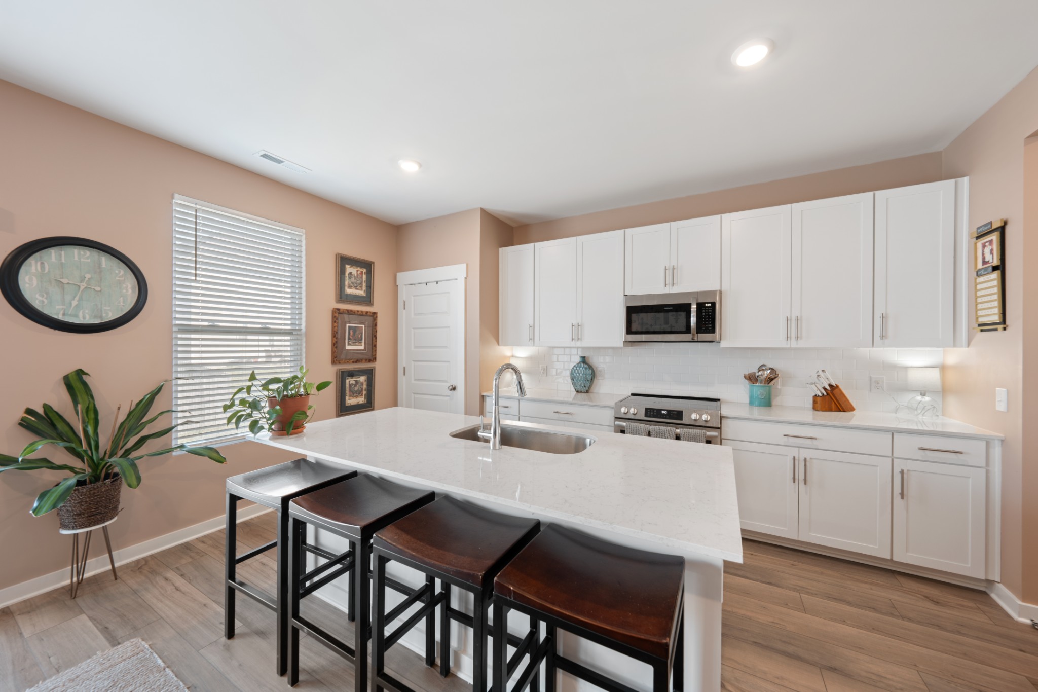 158 Southwind Run Spring Hill, TN 37174 - Photo 18 of 43 a kitchen with stainless steel appliances a sink a stove a table and chairs with wooden floor