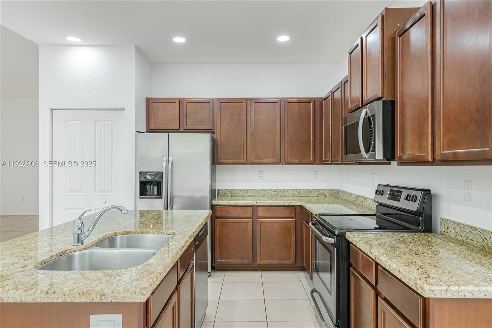 11863 Southwest 253rd Terrace Homestead, FL 33032 - Photo 5 of 30 a kitchen with stainless steel appliances granite countertop a sink stove and refrigerator