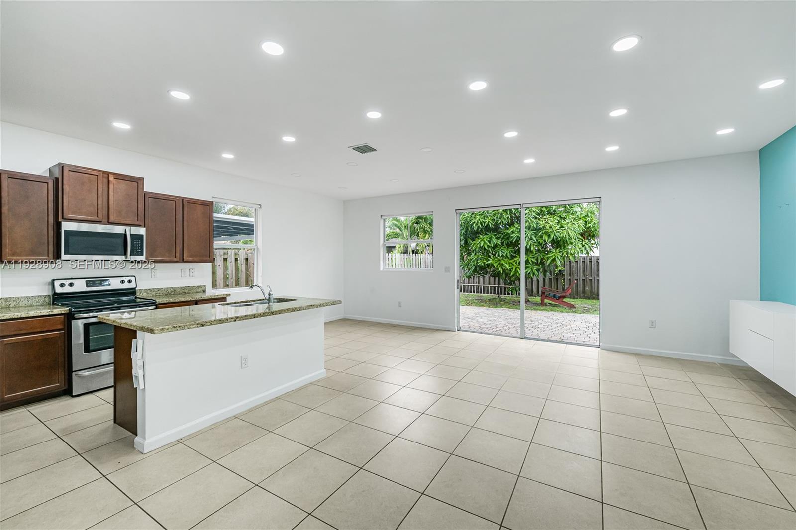 11863 Southwest 253rd Terrace Homestead, FL 33032 - Photo 6 of 30 a kitchen with stainless steel appliances granite countertop a stove a sink a microwave and a refrigerator