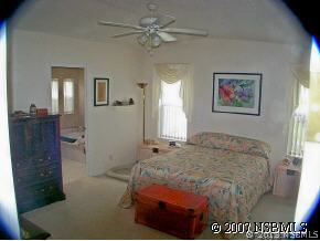 403 Portside Lane Edgewater, FL 32141 - Photo 12 of 12 a bedroom with a bed and a chandelier