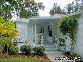 403 Portside Lane Edgewater, FL 32141 - Photo 5 of 12 a view of a white house with a small yard and potted plants
