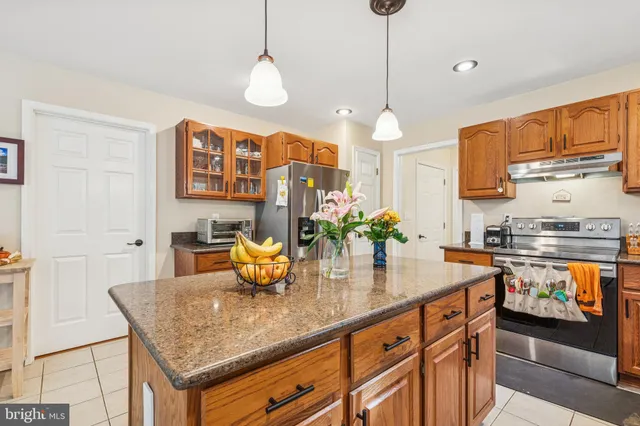 a kitchen with stainless steel appliances granite countertop a sink a center island and cabinets