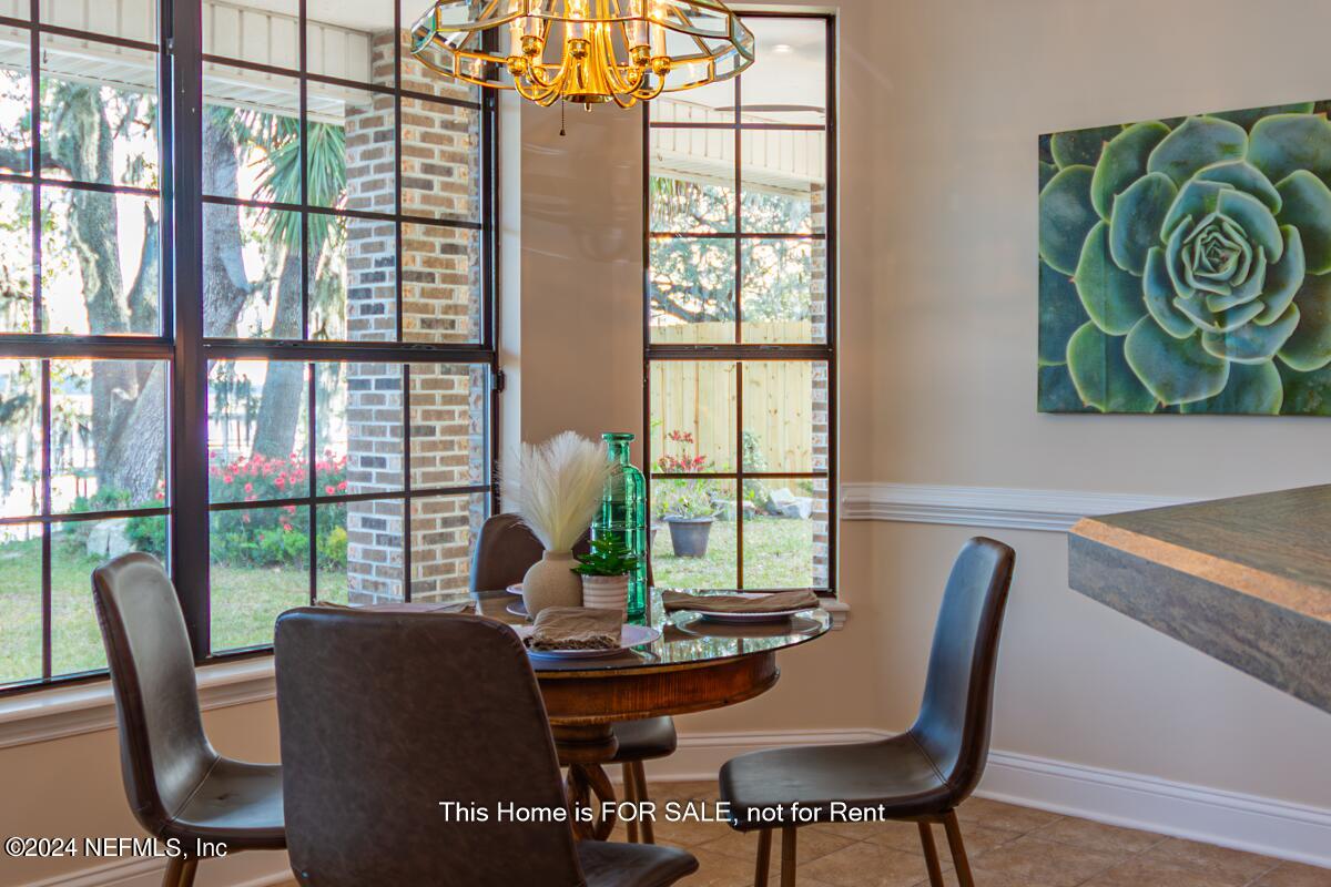 5745 Sheffield Road Jacksonville, FL 32226 - Photo 24 of 57 a dining room with furniture a rug and a potted plant