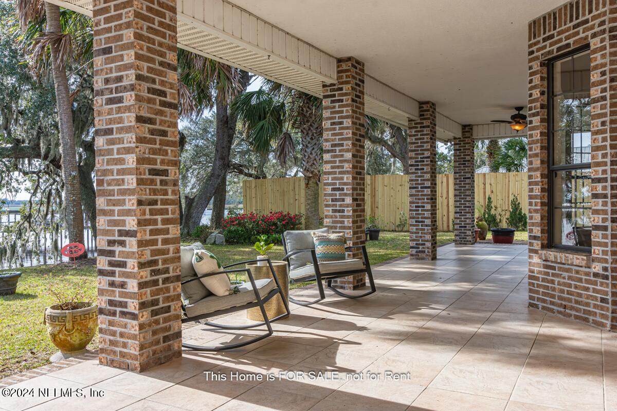5745 Sheffield Road Jacksonville, FL 32226 - Photo 41 of 57 a view of a patio with dining table and chairs and potted plants