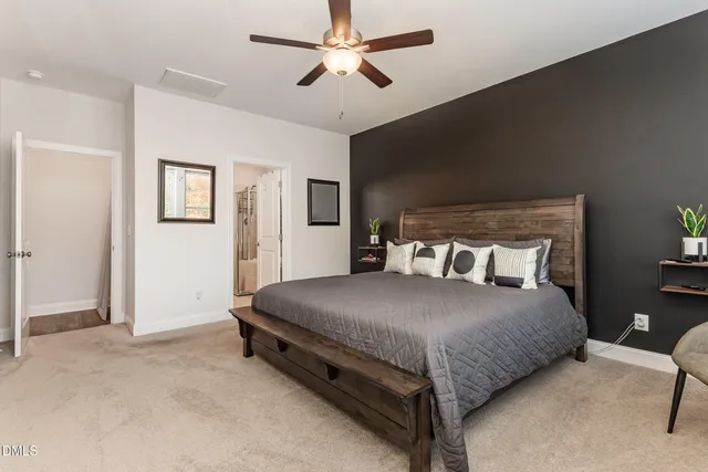 a view of a white house next to a yard with a large tree