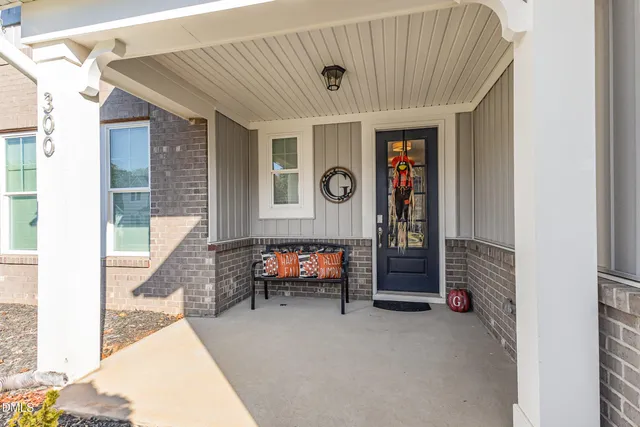 a kitchen with stainless steel appliances granite countertop a stove a refrigerator a kitchen island a sink dishwasher and a dining table with wooden floor