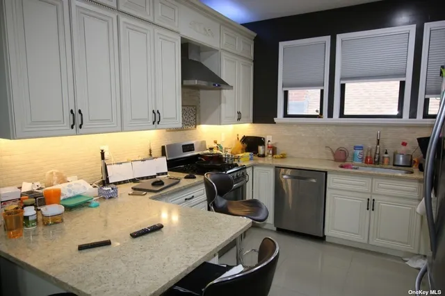 a kitchen with a sink a stove and white cabinets