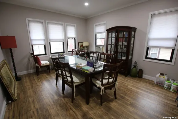 a view of a a dining room with furniture window and wooden floor