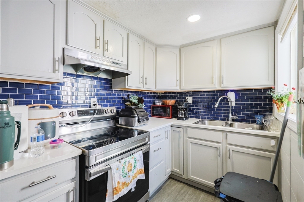 104 Oak Street Fall River, MA 02720 - Photo 15 of 37 a kitchen with white cabinets and white appliances
