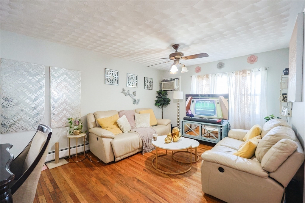 104 Oak Street Fall River, MA 02720 - Photo 6 of 37 a living room with furniture a chandelier and a flat screen tv