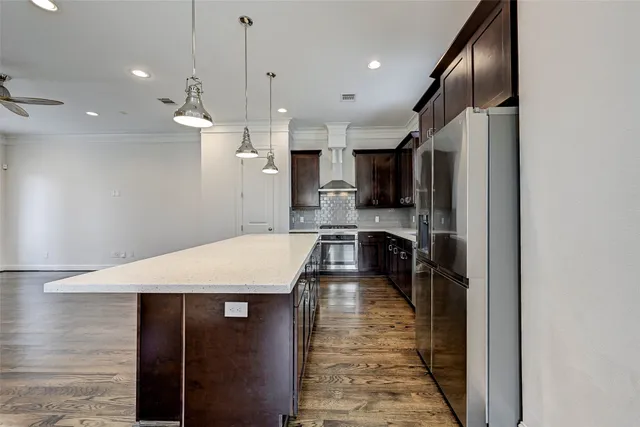 a large kitchen with stainless steel appliances kitchen island a refrigerator oven a sink with a dining table and chairs