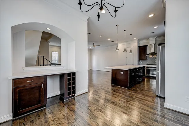 a kitchen with kitchen island a stove a sink and a wooden floors