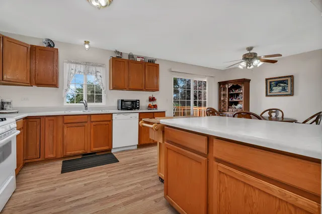 a kitchen with stainless steel appliances granite countertop a sink cabinets and wooden floor