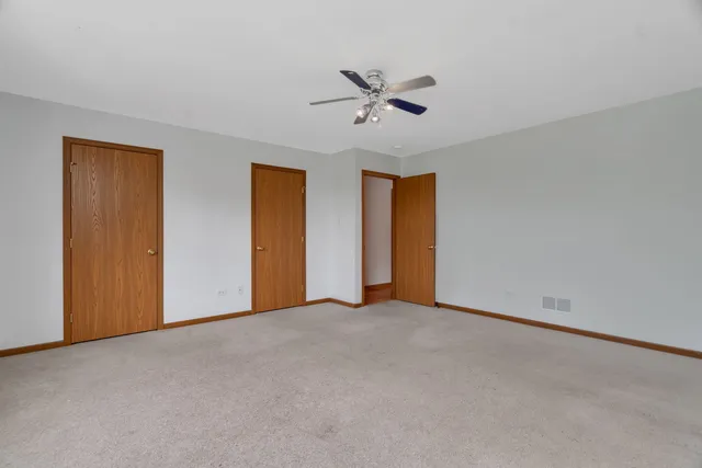 a view of an empty room with a ceiling fan