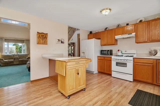 a kitchen with a sink cabinets stainless steel appliances and wooden floor