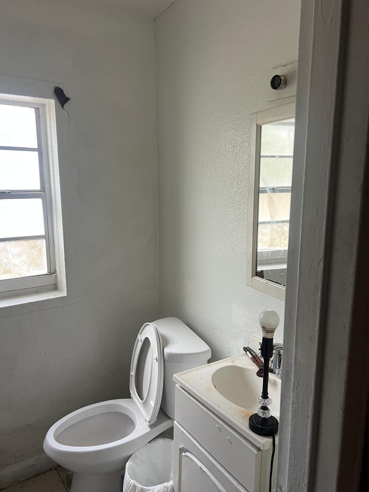 5846 Abelia Road Jacksonville, FL 32209 - Photo 7 of 15 a white toilet sitting next to a bathroom sink