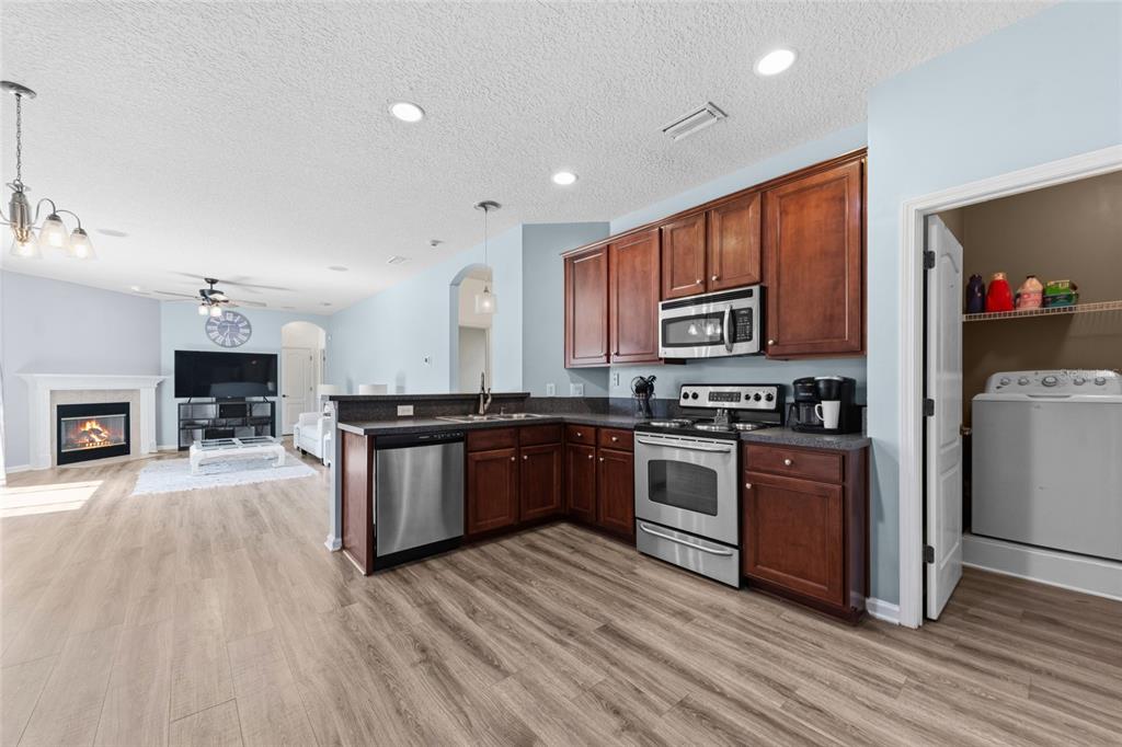 45095 Dutton Way Callahan, FL 32011 - Photo 11 of 36 a kitchen with granite countertop a stove top oven and cabinets