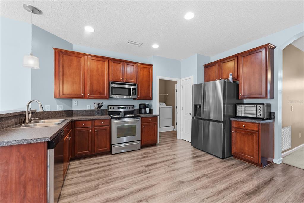 45095 Dutton Way Callahan, FL 32011 - Photo 12 of 36 a kitchen with stainless steel appliances granite countertop a refrigerator stove and sink