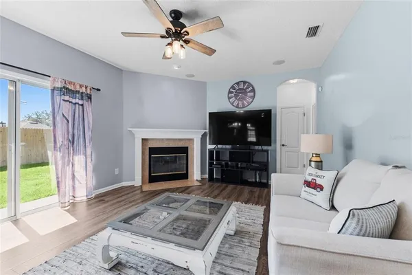 a living room with furniture a fireplace and a flat screen tv