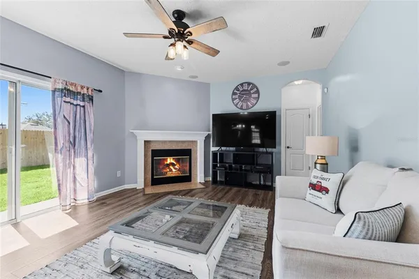 a view of a livingroom with furniture a fireplace wooden floor and a chandelier